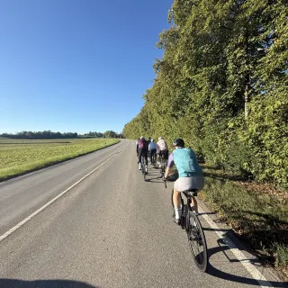 Die Fahrradgruppe auf der Landstraße bei Sonnenschein am Morgen