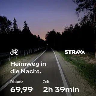 Nachts mit dem Rennrad auf dem Radweg nördlich Sauerlach. Der Lichtkegel meiner Beleuchtung fällt auf den Radweg. Auf dem Bild ist Text von Strava: 69,99 km in 2 Stunden und 39 Minunten bei 330 Höhenmetern