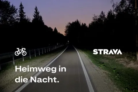 Nachts mit dem Rennrad auf dem Radweg nördlich Sauerlach. Der Lichtkegel meiner Beleuchtung fällt auf den Radweg. Auf dem Bild ist Text von Strava: 69,99 km in 2 Stunden und 39 Minunten bei 330 Höhenmetern